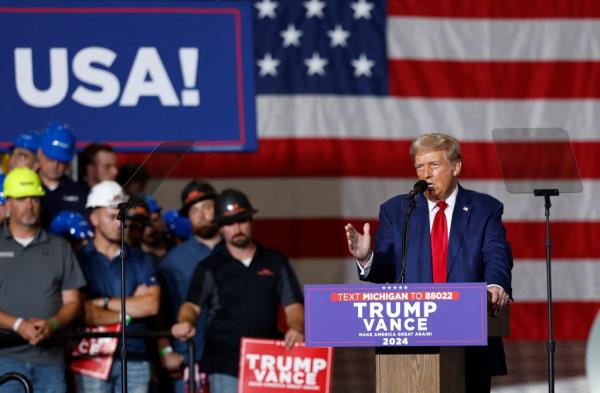 Former US President Do<em></em>nald Trump speaking into a microphone at a campaign event in Walker, Michigan, on September 27, 2024
