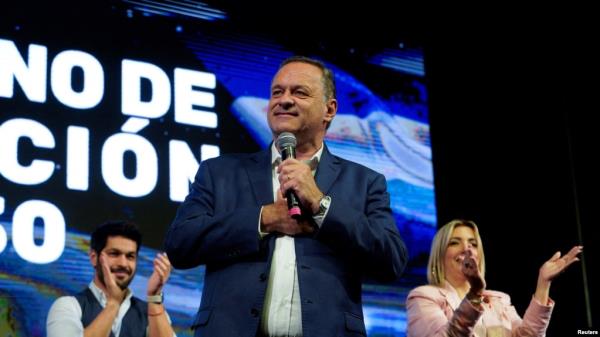 Natio<em></em>nal Party presidential candidate Alvaro Delgado addresses supporters with his running mate Valeria Ripoll and Colorado Party presidential candidate Andres Ojeda following the first exit polls during the general election, in Montevideo, Uruguay October 27, 2024.