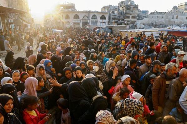 Palestinians gather to buy bread from a bakery,
